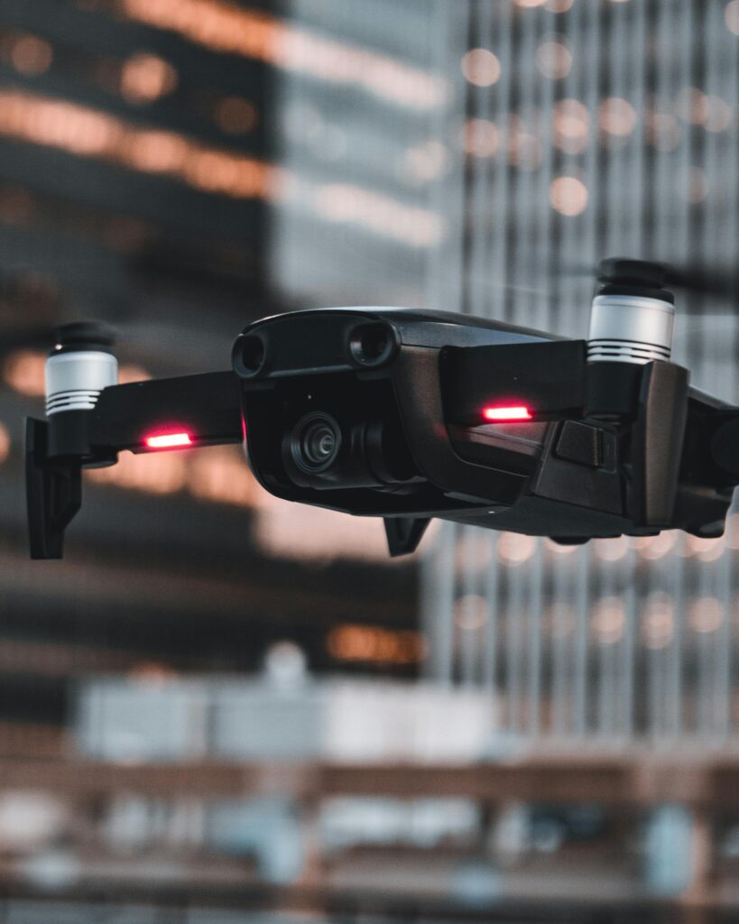 pexels-photo-19131319-19131319 Dynamic close-up of a drone flying against a background of city buildings, highlighting urban technology.